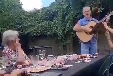 Warren playing guitar and singing to Mom at her eightieth birthday celebration.